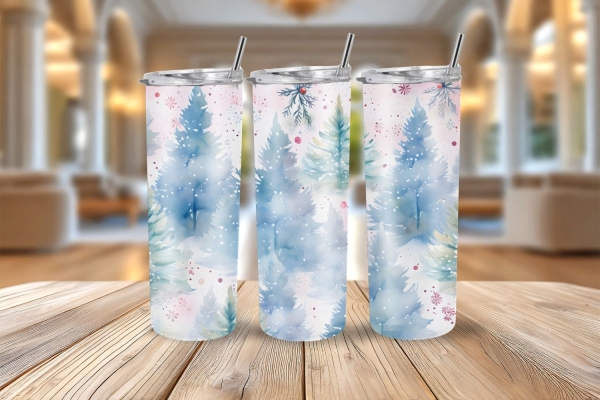 Drei Thermobecher mit winterlichem Design aus blauen Tannenbäumen und roten Akzenten, präsentiert auf Holztisch vor heller Raumkulisse.